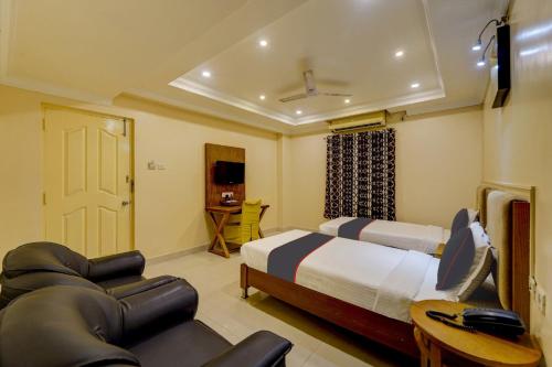 a bedroom with two beds and a couch and a tv at G Silver Ashok Nagar in Chennai