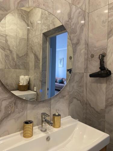 a bathroom with a sink and a mirror at Новые апартаменты рядом с EXPO in Taldykolʼ