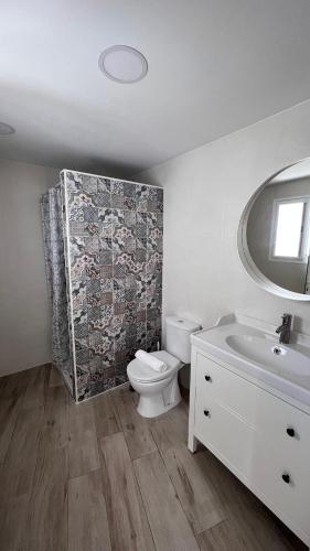 a bathroom with a toilet and a sink and a mirror at Salobre Blue Sky 2 in Salobre