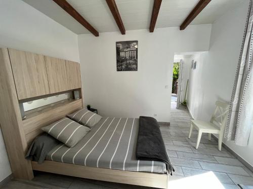 a bedroom with a large bed and a chair at Beach House in Fos-sur-Mer