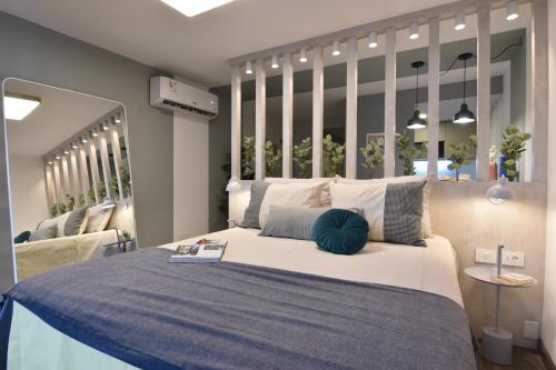 Exclusivo apartamento en Punta Carretas في مونتيفيديو: غرفة نوم بسرير كبير مع مرآة كبيرة