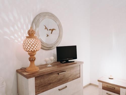 a room with a tv on a dresser with a mirror at Mare Adesso in Polignano a Mare