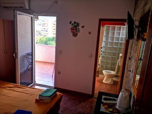 a bedroom with a door open to a bathroom with a toilet at Kuća Todorović in Budva