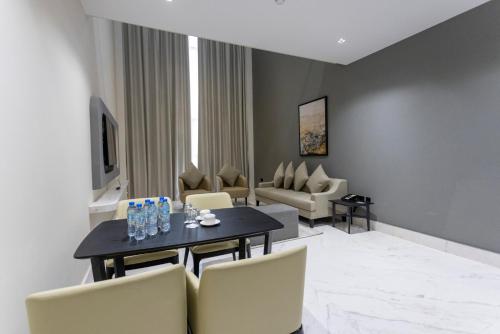 a living room with a dining table and chairs at Alberni Jabal Hafeet Hotel Al Ain in Al Ain