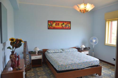 a bedroom with a bed and two tables and a lamp at Gole Dell'Alcantara Villa Lucia in Motta Camastra