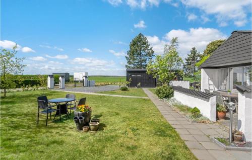 a garden with a table and chairs in the grass at Four-Bedroom Holiday Home In Odder in Odder