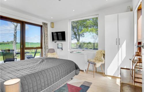 ein Schlafzimmer mit einem Bett und einem großen Fenster in der Unterkunft 4 Bedroom Awesome Home In Odder in Odder