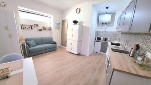 uma cozinha e uma sala de estar com um sofá num quarto em Chez Mélanie et Rodolphe em La Ciotat