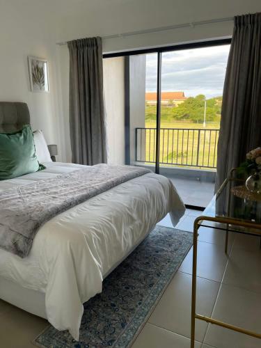 a bedroom with a bed and a large window at 151 Ballito Luxury Villa in Ballito
