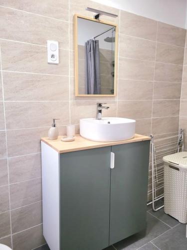 une salle de bain avec un lavabo et un miroir dans l'établissement Chez Mélanie et Rodolphe, à La Ciotat