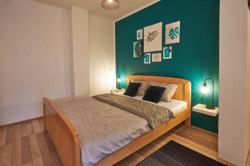 a bedroom with a bed with a green wall at Apartment Green in Poreč