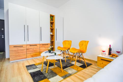 ブカレストにあるContemporary Studio with Balcony - New Buildingのリビングルーム(オレンジの椅子、テーブル付)