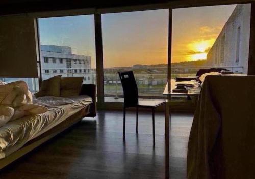a living room with a couch and a large window at São Pedro Apartment in Vila Franca do Campo