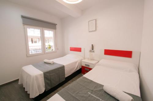 a bedroom with two beds and a window at RONDA Centro Levante Beach in Benidorm