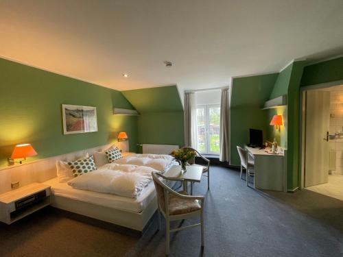 sypialnia z zielonymi ścianami, łóżkiem i biurkiem w obiekcie Eichenhof Hotel Garni w mieście Groß Köris