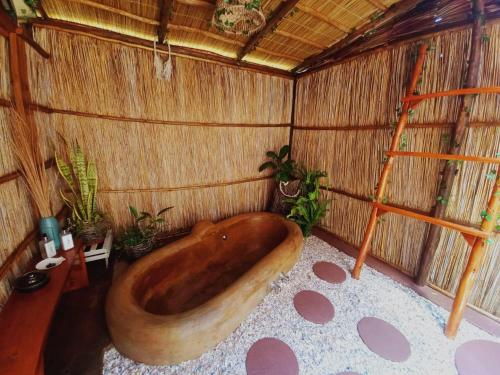 a large wooden tub in a room with plants at MOZBEVOK Coconut View Resort in Ponta do Ouro