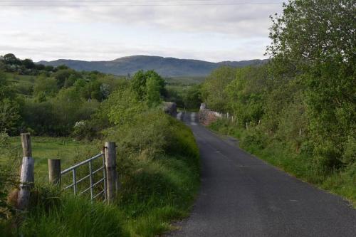 a dirt road with a fence on the side at Eanymore Farm Cottage in Donegal