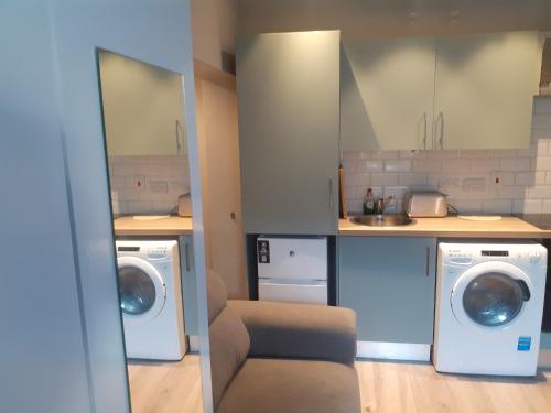 eine Küche mit 2 Waschmaschinen und einem Waschbecken in der Unterkunft Spacious Studio-Dublin 3 in Dublin