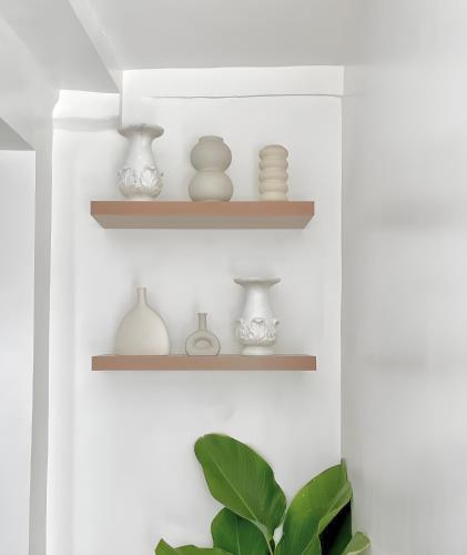a shelf with vases and vases on it at NEW Modern Suite near Airport & Beach in Sudtungan