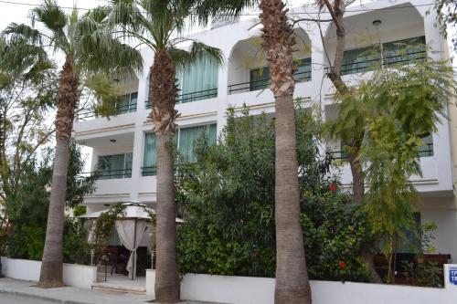 a hotel with palm trees in front of it at Marianna Hotel Apartments in Limassol