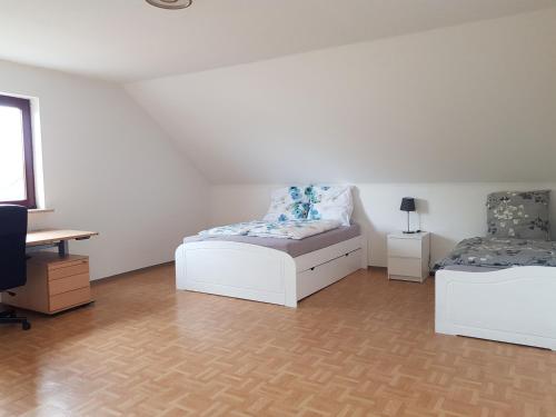 a white room with two beds and a desk at Beautiful 3 rooms apartment 110 m2, kostenloser Parkplatz, großer Balkon in Heßdorf