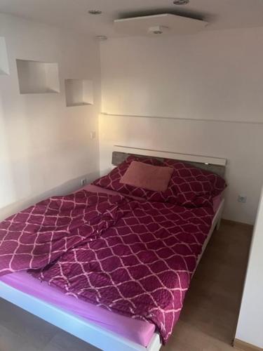 1 dormitorio con cama morada y edredón morado en Gästestübchen, en Diez