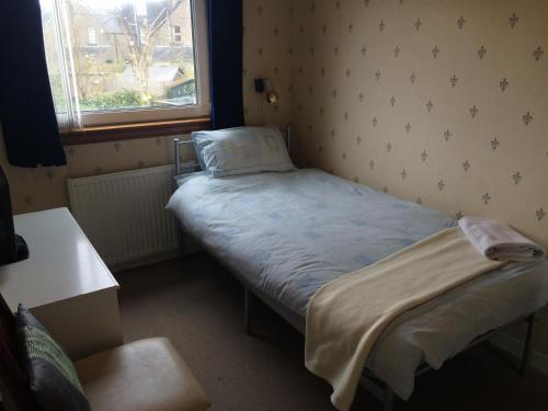a small bed in a small room with a window at Ardgarry Holiday House in Inverness