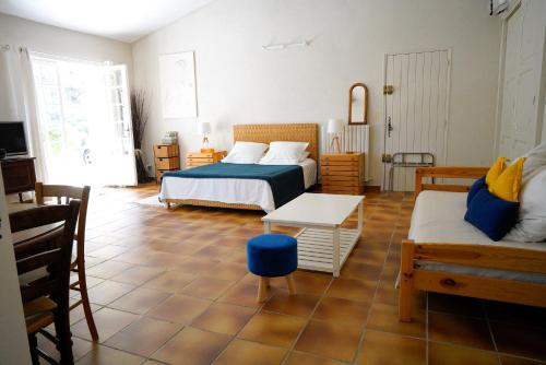 - une chambre avec 2 lits, une table et un canapé dans l'établissement Villa Bois Romay dans le Luberon avec piscine, tennis et pétanque., à La Bastide-des-Jourdans