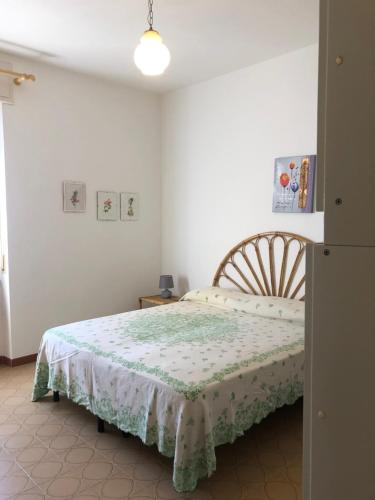 a bedroom with a bed with a green and white blanket at APPARTAMENTO NEL CENTRO DI SANTA TERESA GALLURA in Santa Teresa Gallura