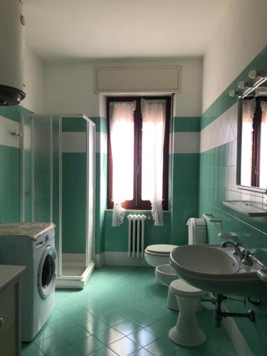 a green bathroom with two toilets and a sink at APPARTAMENTO NEL CENTRO DI SANTA TERESA GALLURA in Santa Teresa Gallura