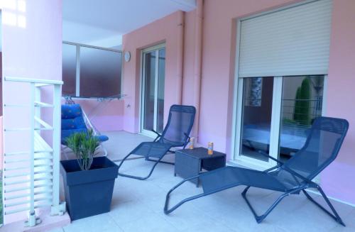 two chairs and a table in a room with pink at Mer, plages, piscine, paysages ydilliques:LE REVE! in Théoule-sur-Mer