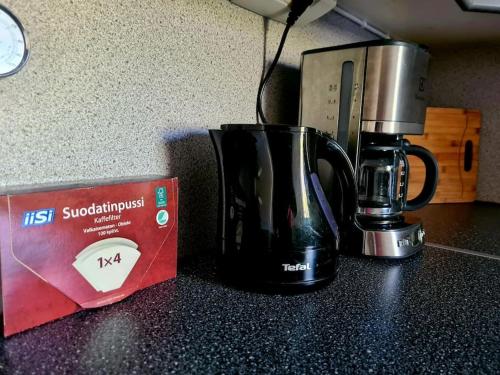 a black coffee mug sitting next to a box on a counter at Vintage house for rent in Klaukkala