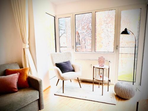 a living room with a chair and a window at Das Stader Refugium in Stade
