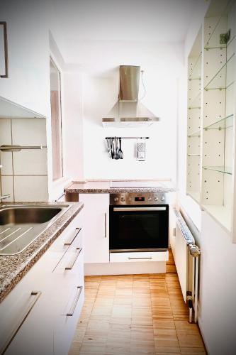 a white kitchen with a sink and a microwave at Das Stader Refugium in Stade
