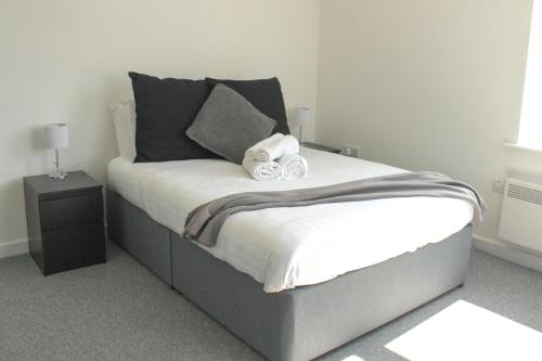 Una cama con toallas en un dormitorio en Homely 1Bed Apt with Transport Links to CC en Heywood