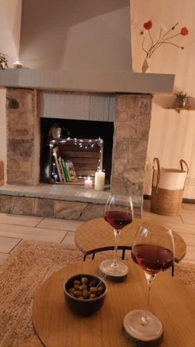 - deux verres de vin sur une table devant une cheminée dans l'établissement Appartement - Brando, à Brando