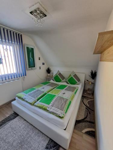 a bedroom with a bed with green sheets and pillows at Ferienwohnung galina in Rockenhausen