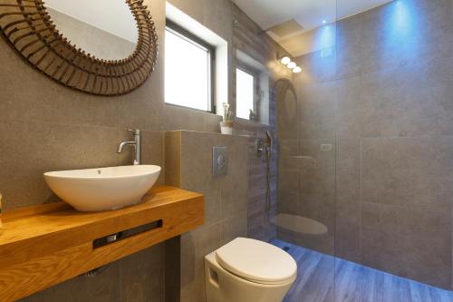a bathroom with a sink and a toilet and a mirror at AirTLV - Bazel Central Apartment With Balcony in Tel Aviv