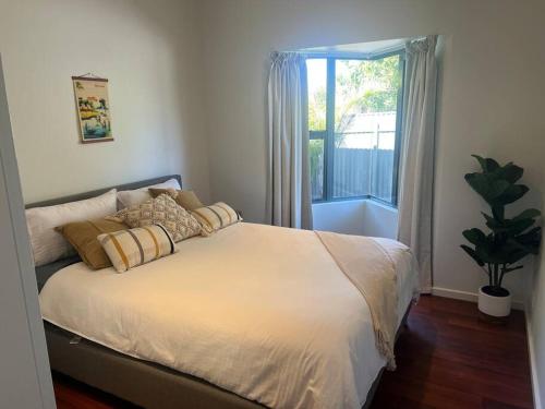een slaapkamer met een groot bed en een raam bij Stylish 3BR home with outdoor entertaining in Oaklands
