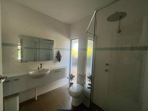 een badkamer met een toilet, een wastafel en een douche bij Stylish 3BR home with outdoor entertaining in Oaklands