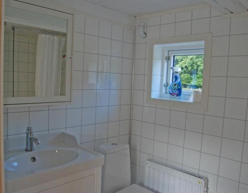 ein Bad mit einem Waschbecken, einem WC und einem Fenster in der Unterkunft Lugnet in Hörby