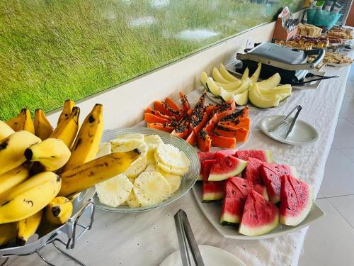 a table topped with plates of fruit and bananas at Ibiza Barra Hotel in Rio de Janeiro