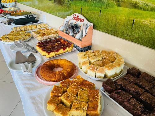 a table topped with different types of pastries and desserts at Ibiza Barra Hotel in Rio de Janeiro