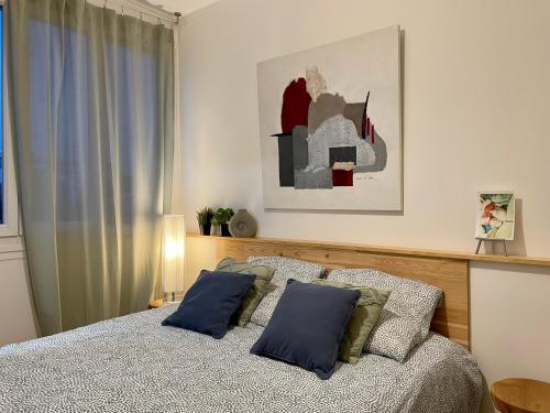 sypialnia z łóżkiem z 2 niebieskimi poduszkami w obiekcie Green Hôpitaux w mieście Bron