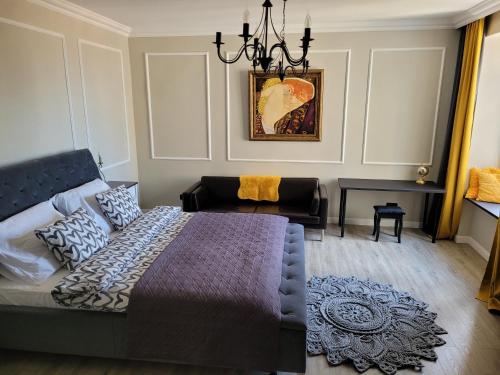 Schlafzimmer mit einem Bett und einem Kronleuchter in der Unterkunft Apartament Danoe in Łódź