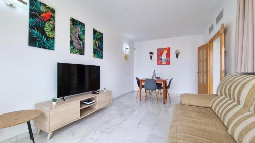 ein Wohnzimmer mit einem Sofa, einem TV und einem Tisch in der Unterkunft Apartment with private balcony and nice views 23 in Benidorm