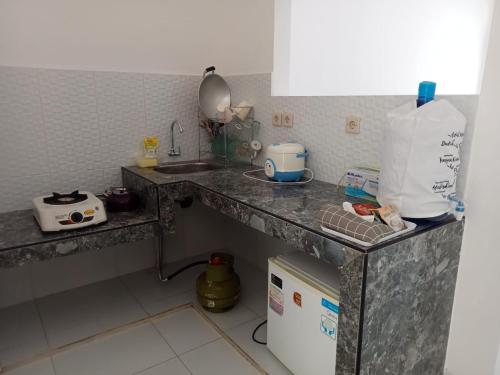 a kitchen with a counter top with a sink at KENARI P25 HOMESTAY in Purwokerto
