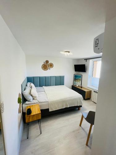 a bedroom with a bed and a table at Apartamenty Dolce Vita in Ostrowo