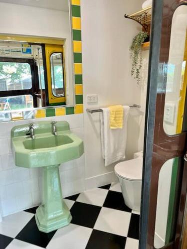 a bathroom with a green sink and a toilet at Yarra Valley Tram Stay in Lilydale