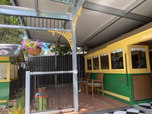 a train house with a porch and a table at Yarra Valley Tram Stay in Lilydale